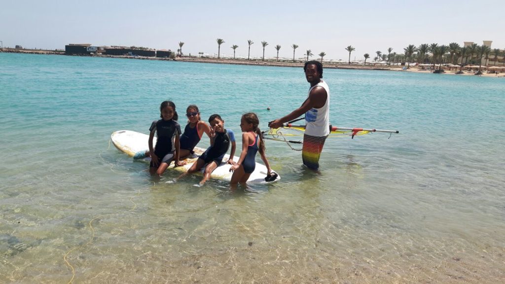 Kinder surf lessons, Kiteboarding, Kitesurfing, Stand-up paddleboarding, Water sports in Hurghada, Surfing lessons in Egypt, Red Sea adventures, Family-friendly water sports, Hurghada beaches, Beginner-friendly surf school